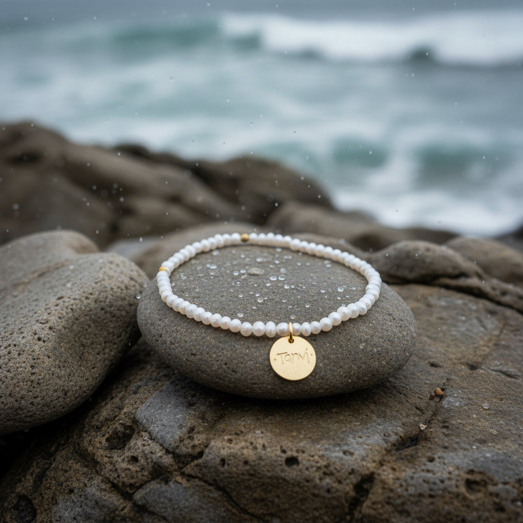 pearl bracelet with charm on rocks